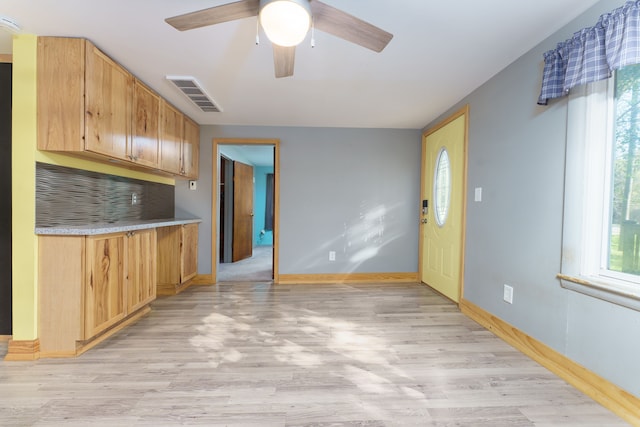 kitchen featuring decorative backsplash, ceiling fan, and light wood-type flooring