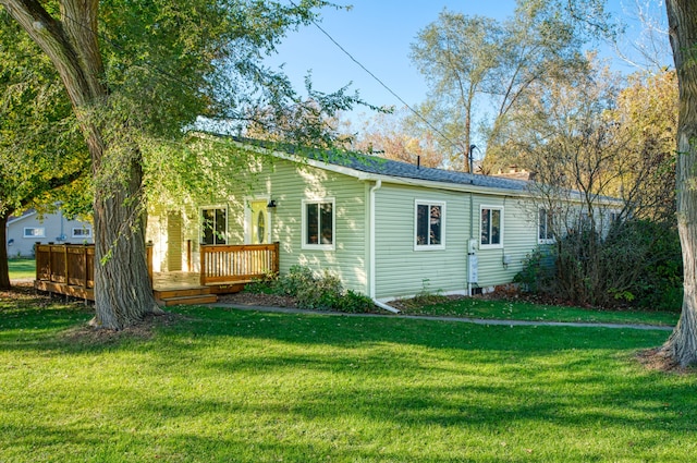 rear view of house with a wooden deck and a yard