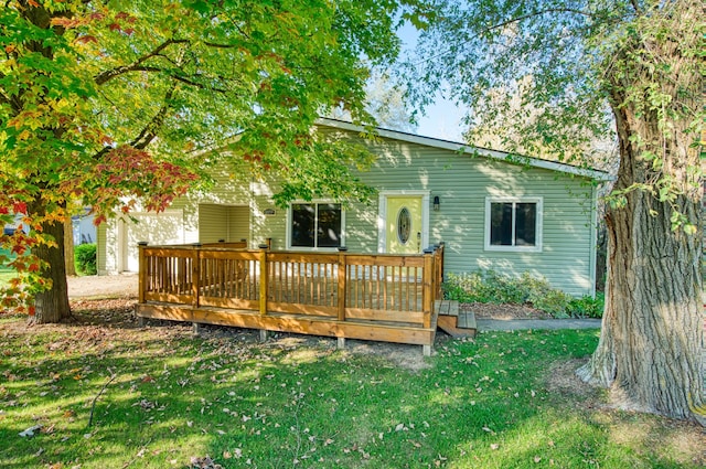 rear view of house with a deck and a lawn