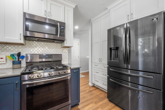 kitchen with light hardwood / wood-style floors, white cabinetry, blue cabinetry, and appliances with stainless steel finishes