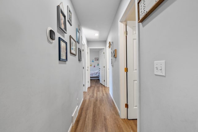 corridor with light hardwood / wood-style floors