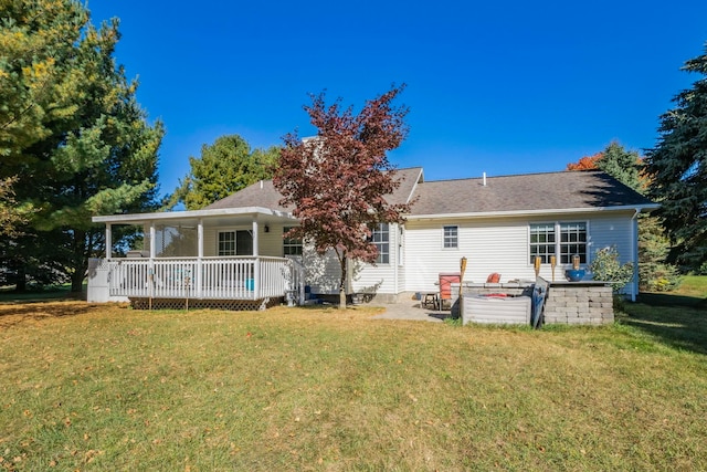 back of house with a deck and a yard