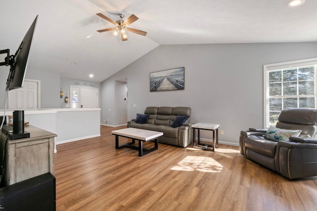 living room with hardwood / wood-style flooring, ceiling fan, and lofted ceiling