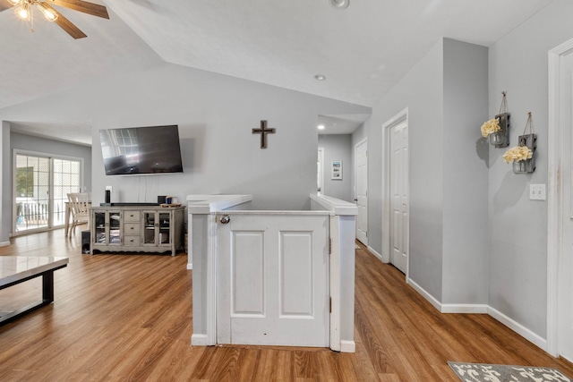 kitchen with light hardwood / wood-style floors, vaulted ceiling, and ceiling fan