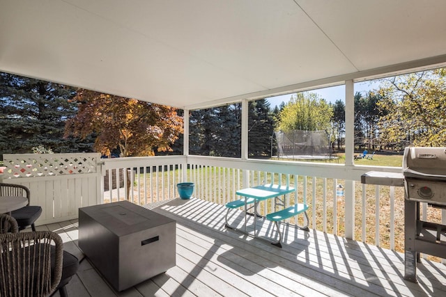 wooden terrace featuring a grill and a trampoline