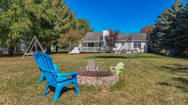 view of yard with a trampoline and an outdoor fire pit