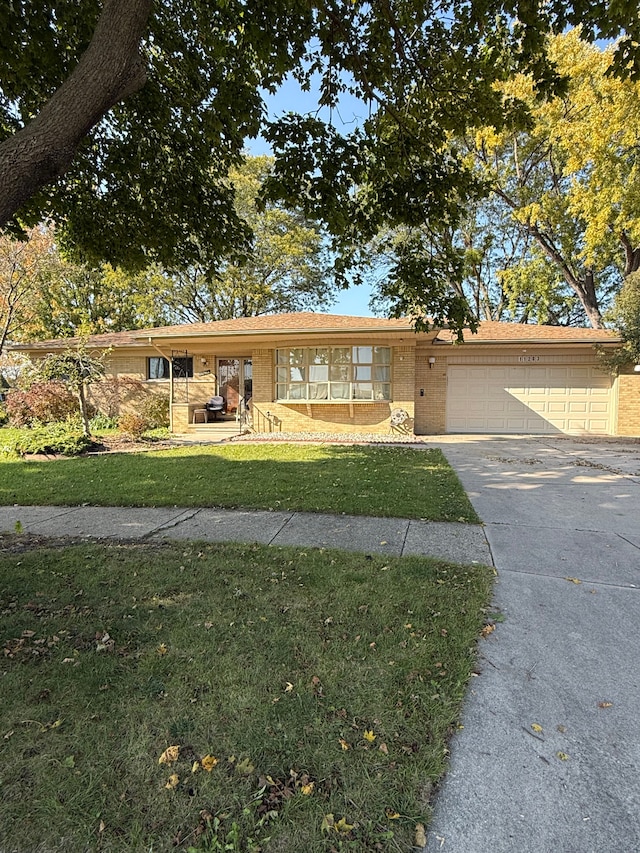 single story home featuring a garage and a front lawn