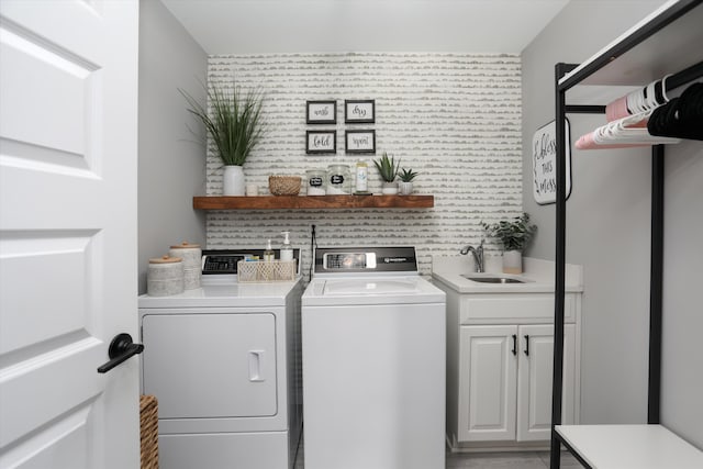 clothes washing area with cabinets, separate washer and dryer, and sink