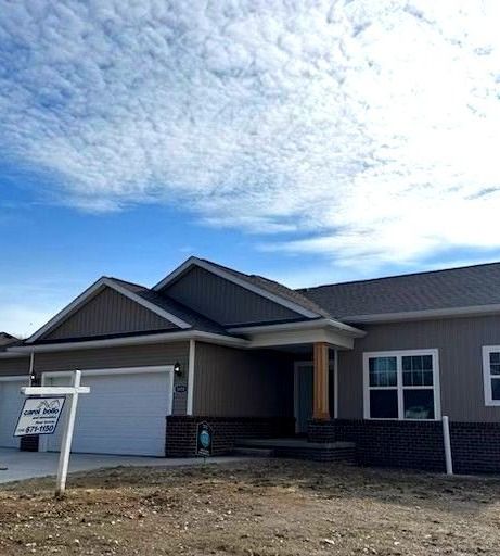 view of front of property with driveway, brick siding, and an attached garage