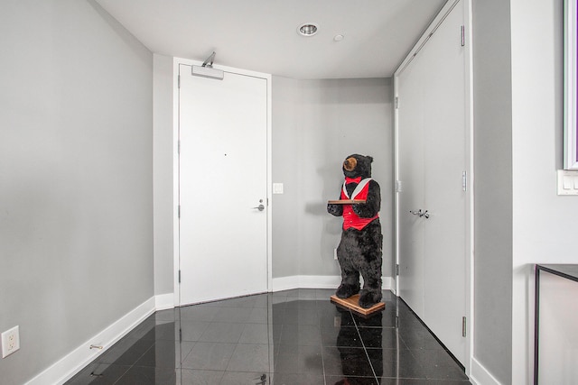 doorway to outside with dark tile patterned floors