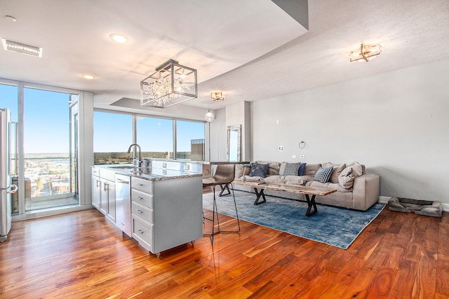 kitchen with sink, kitchen peninsula, light hardwood / wood-style floors, a breakfast bar area, and appliances with stainless steel finishes