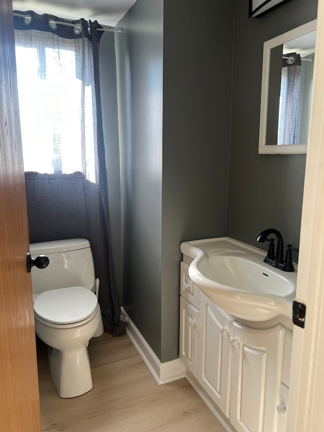 bathroom with hardwood / wood-style floors, vanity, and toilet