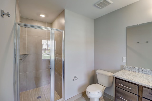 bathroom featuring tile patterned flooring, vanity, toilet, and walk in shower