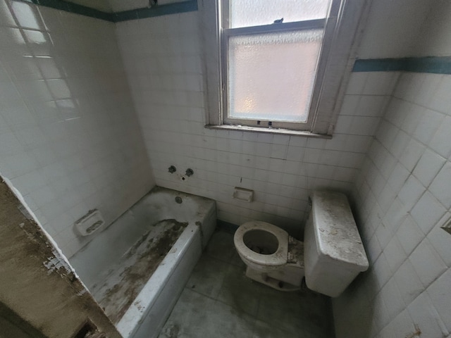 bathroom featuring a tub to relax in, plenty of natural light, tile walls, and toilet