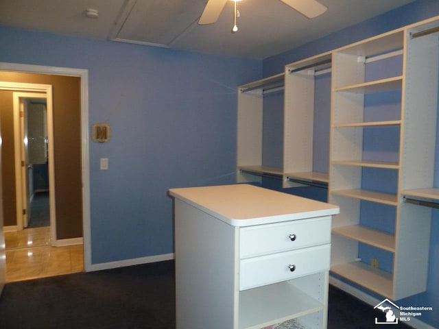 walk in closet with dark tile patterned flooring and ceiling fan