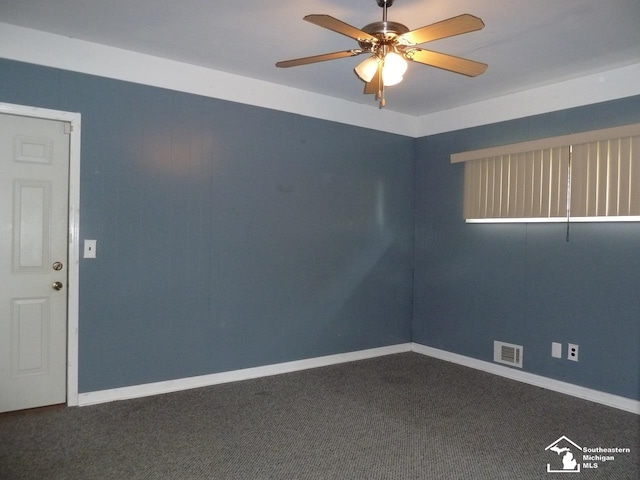 spare room with ceiling fan and dark carpet