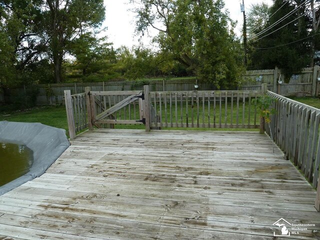 wooden terrace featuring a yard