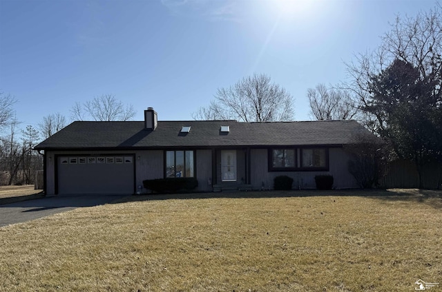 ranch-style home with aphalt driveway, a garage, a front yard, and a chimney