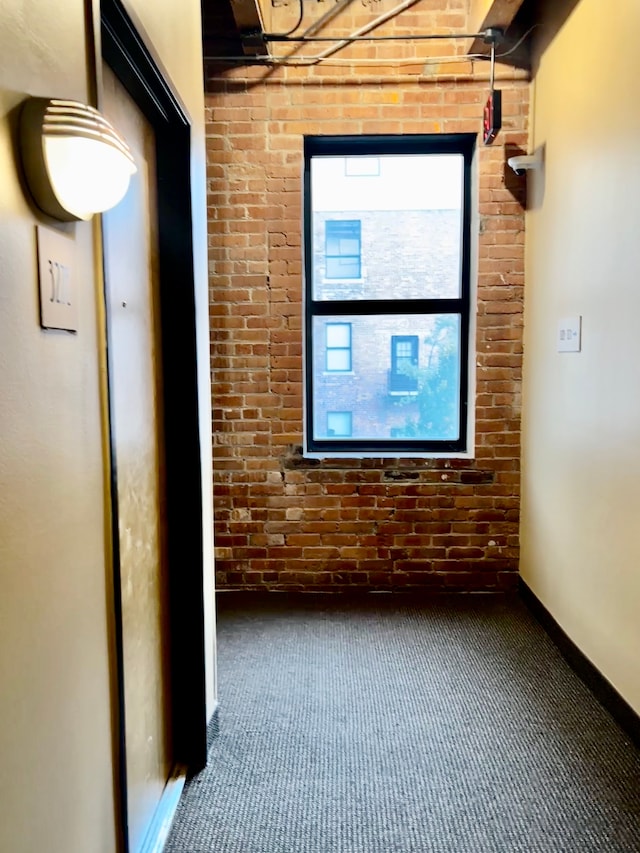 unfurnished room featuring brick wall