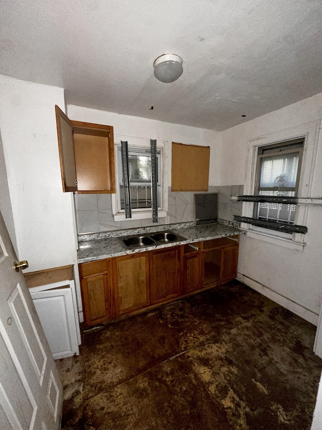 kitchen with a textured ceiling, tasteful backsplash, and sink