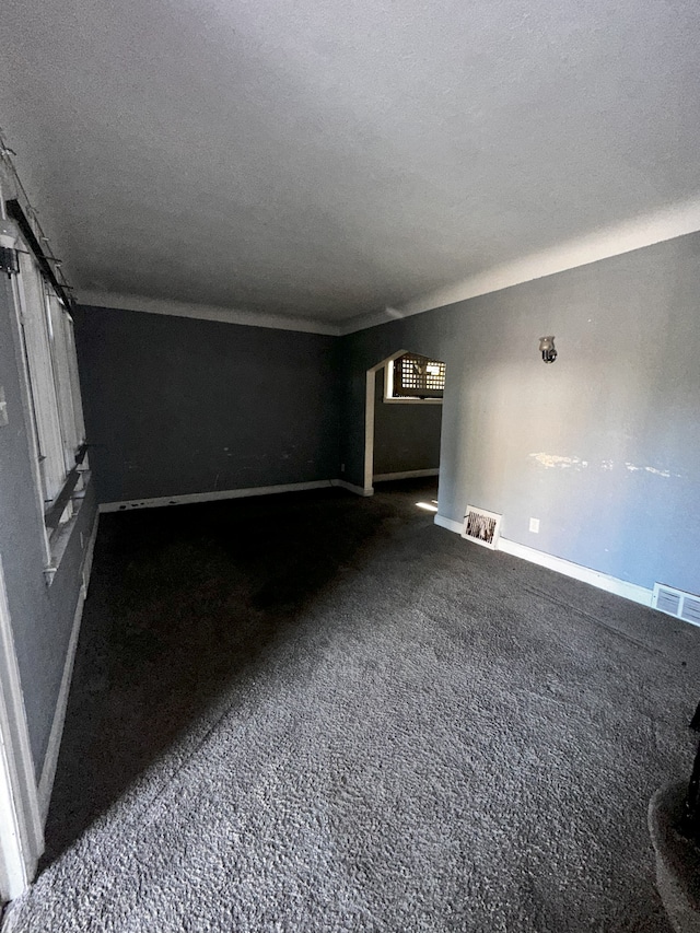 empty room with carpet and a textured ceiling