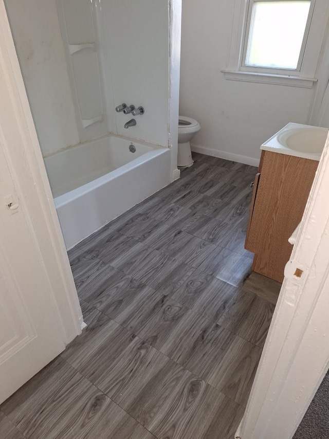 full bathroom with shower / tub combination, vanity, wood-type flooring, and toilet