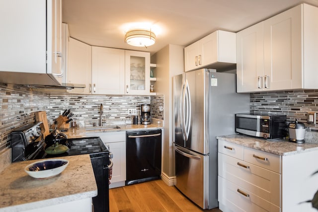 kitchen featuring white cabinets, sink, light hardwood / wood-style floors, and black appliances