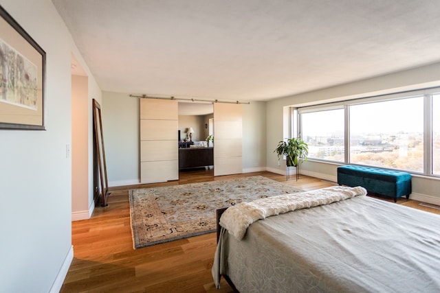 bedroom featuring rail lighting and hardwood / wood-style flooring