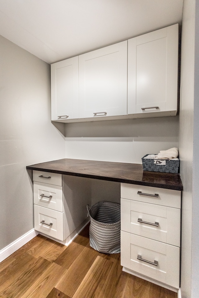 unfurnished office with wood-type flooring and built in desk