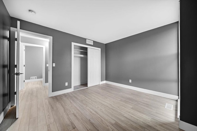 unfurnished bedroom featuring a closet and light hardwood / wood-style flooring