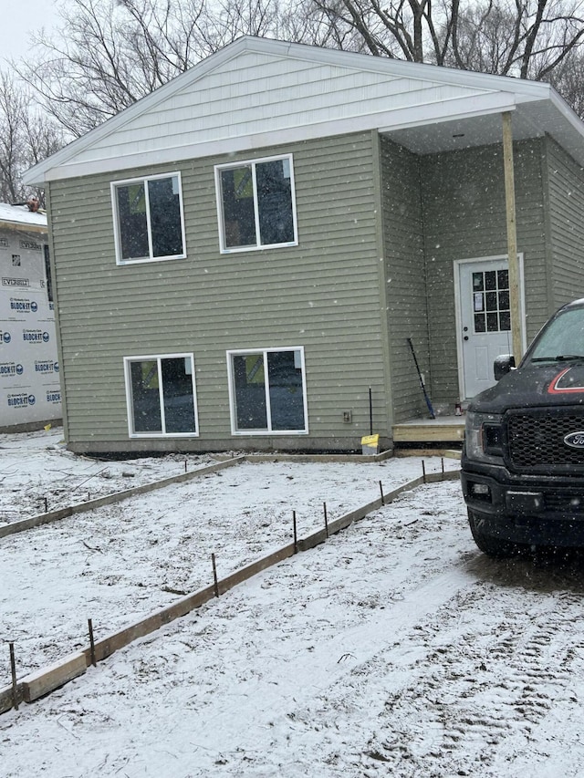 view of snow covered back of property