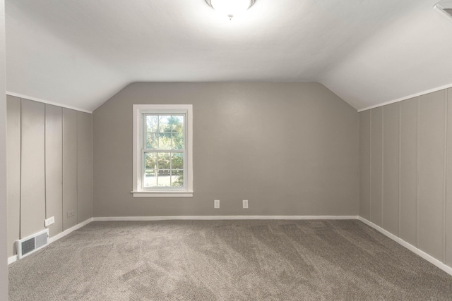 additional living space with carpet flooring and lofted ceiling