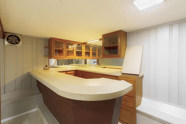 kitchen with kitchen peninsula, a breakfast bar, and light tile patterned flooring