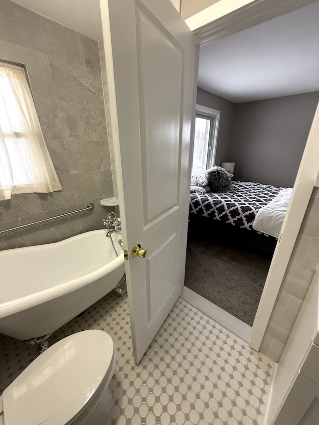 bathroom featuring toilet and a tub