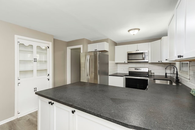 5721 Corunna Ave, Clarkston, MI 48346 - kitchen featuring appliances with stainless steel finishes, a sink, dark countertops, a peninsula, and white cabinets