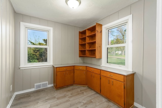 5721 Corunna Ave, Clarkston, MI 48346 - unfurnished office with light wood-style flooring, a decorative wall, healthy amount of natural light, and baseboards