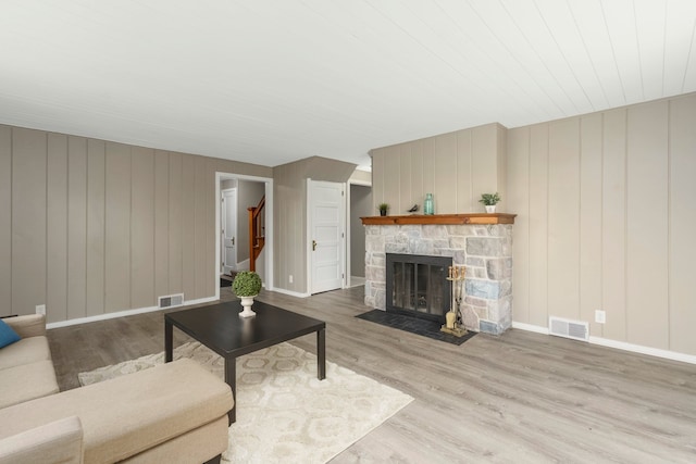 5721 Corunna Ave, Clarkston, MI 48346 - living room featuring a stone fireplace, wood finished floors, wood walls, and baseboards
