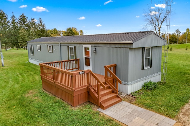 rear view of property with a wooden deck and a yard