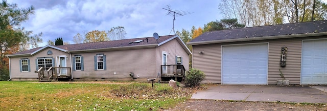 exterior space with a garage, a yard, and crawl space