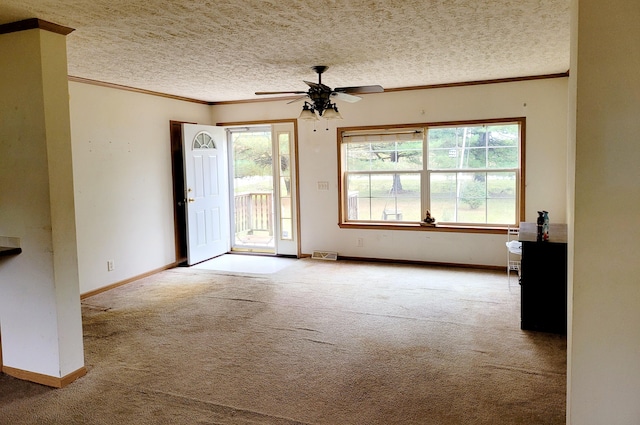 carpeted spare room featuring ornamental molding, a textured ceiling, and baseboards