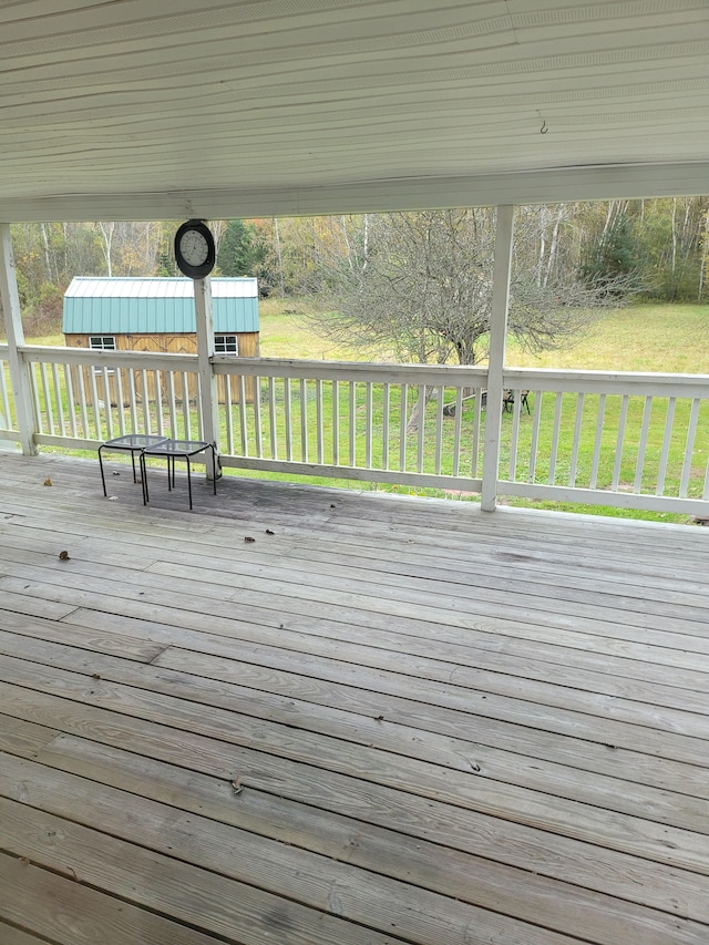 wooden terrace with a lawn and an outbuilding