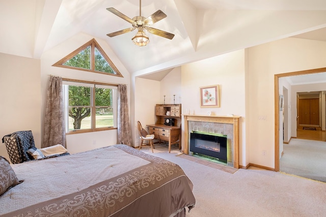 bedroom featuring a tile fireplace, ceiling fan, light colored carpet, and lofted ceiling