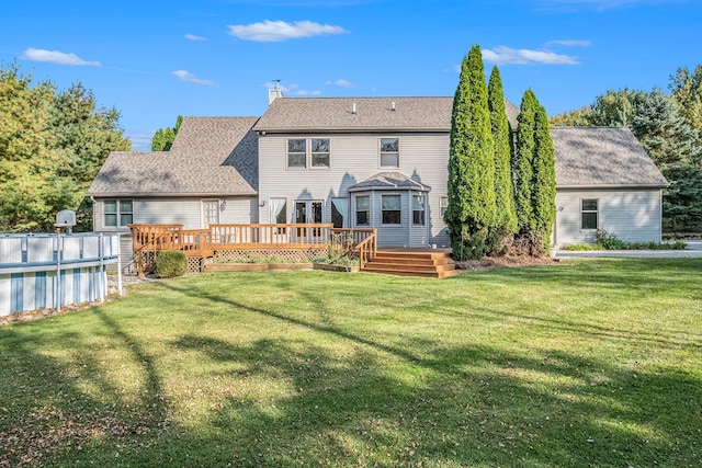 rear view of property with a swimming pool side deck and a yard