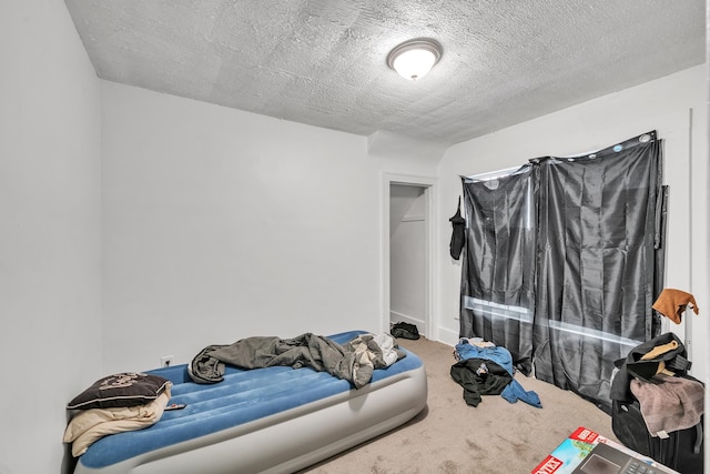 bedroom with carpet and a textured ceiling