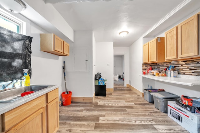 kitchen featuring backsplash, light brown cabinets, sink, and light hardwood / wood-style flooring