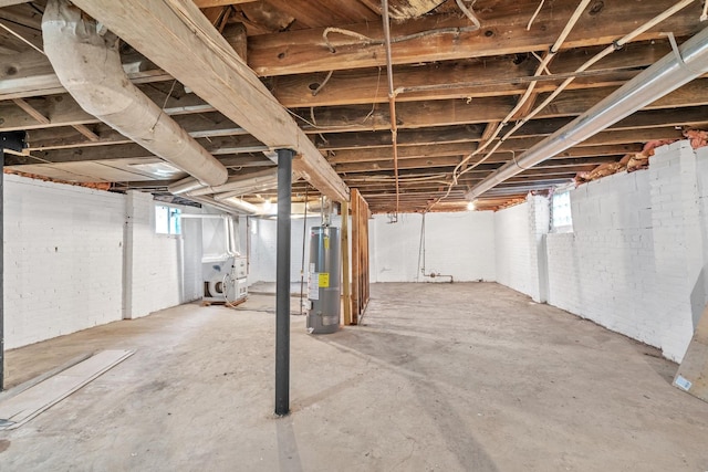 basement with water heater and brick wall