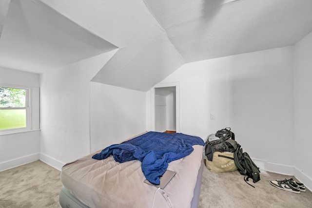 bedroom featuring light carpet and vaulted ceiling