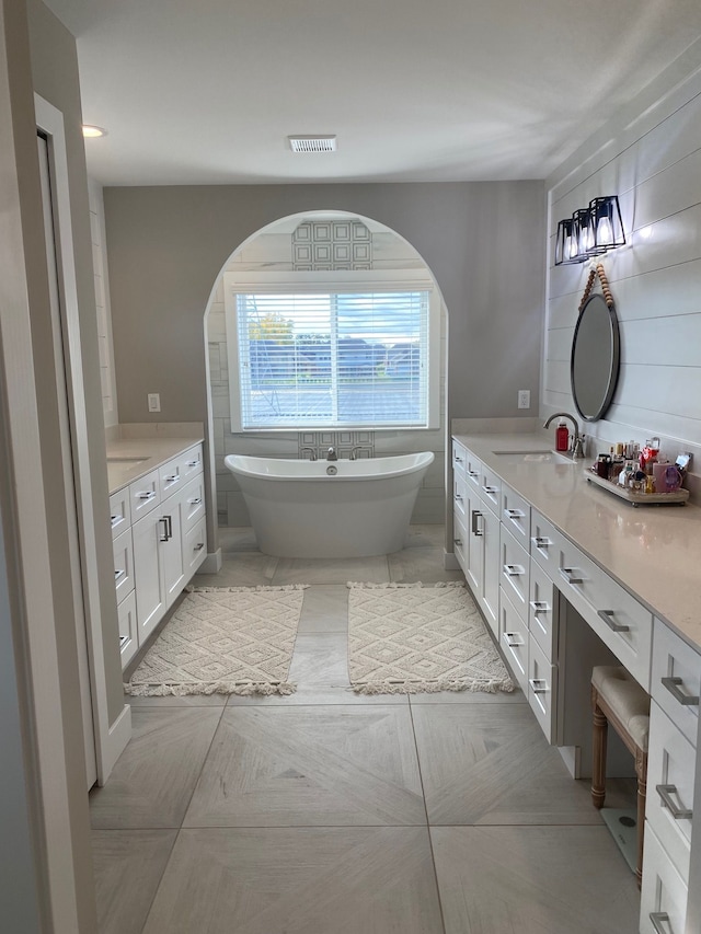 bathroom with a washtub and vanity