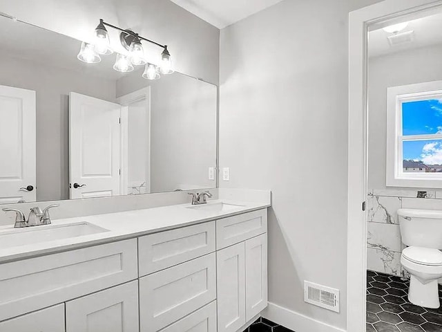 bathroom featuring vanity, toilet, tile patterned flooring, and tile walls