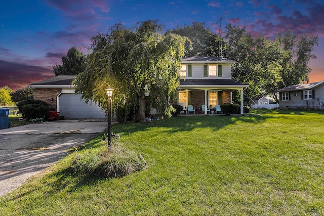 view of front of house featuring a lawn, a porch, and a garage